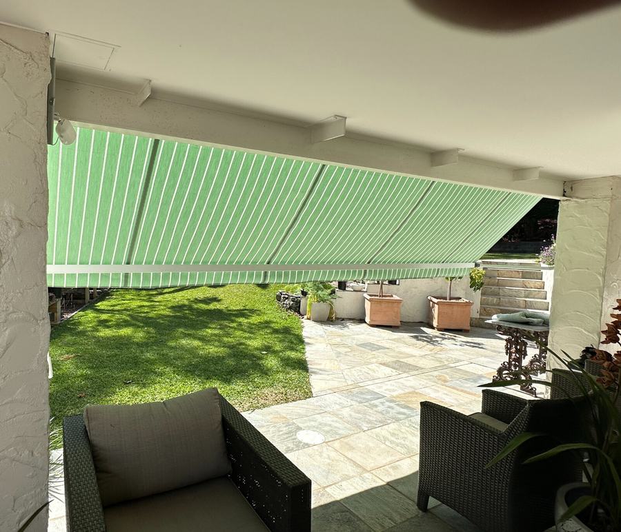 Green and white striped awning over a paved courtyard