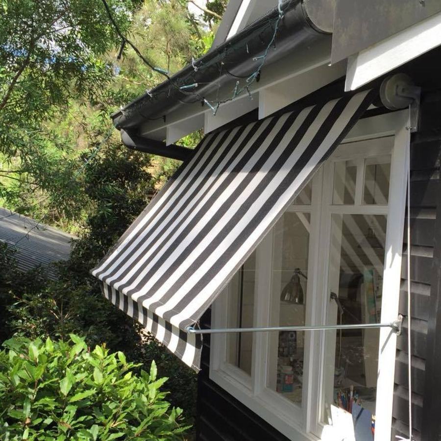 Striped window awning on a weatherboard house